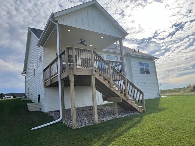 rear view of house featuring ceiling fan and a yard