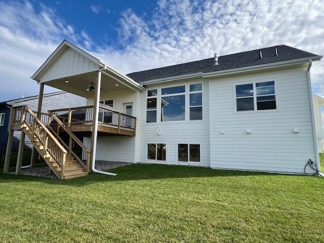 rear view of property featuring a yard and a wooden deck