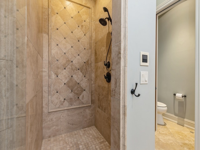 full bathroom with tile patterned flooring, baseboards, a tile shower, and toilet