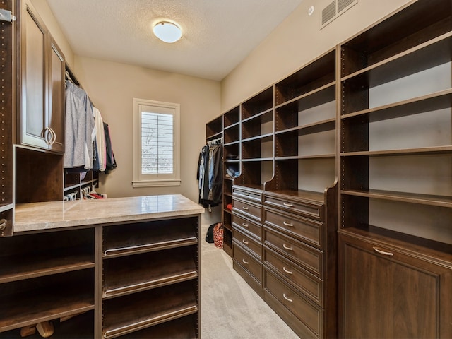 walk in closet with light carpet and visible vents