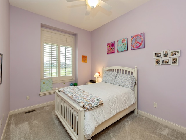 carpeted bedroom featuring a ceiling fan, visible vents, and baseboards