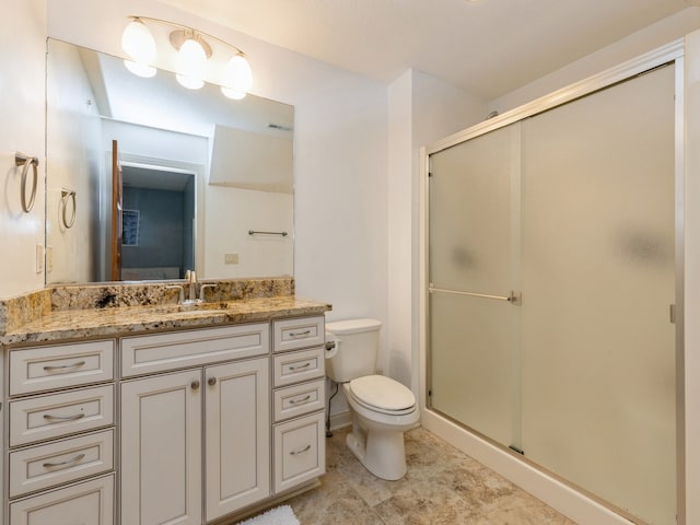 bathroom featuring a stall shower, vanity, and toilet