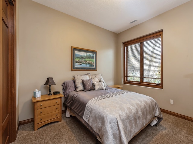 carpeted bedroom featuring baseboards and visible vents