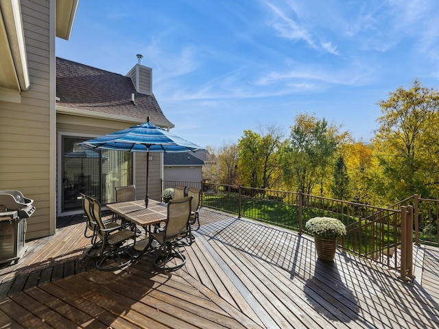 wooden deck featuring outdoor dining area and a grill