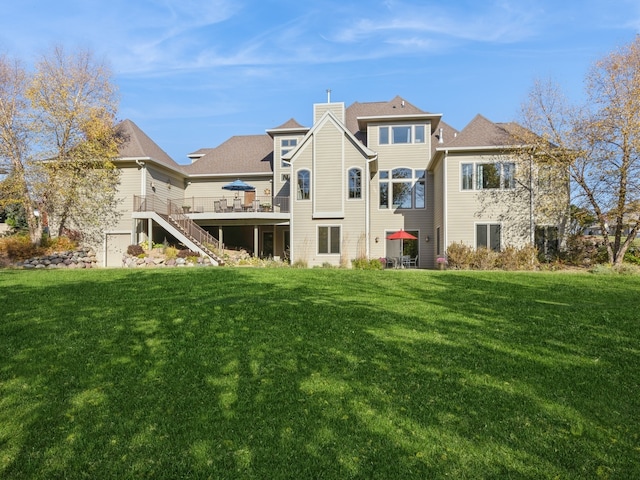 back of property with a wooden deck, a chimney, stairway, and a yard