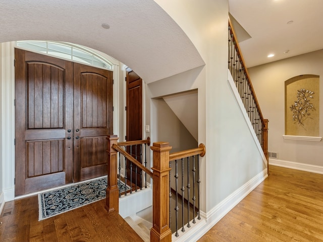 foyer with recessed lighting, wood finished floors, visible vents, and baseboards