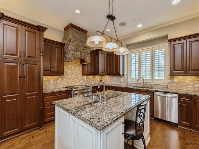 kitchen with wood finished floors, appliances with stainless steel finishes, and a sink