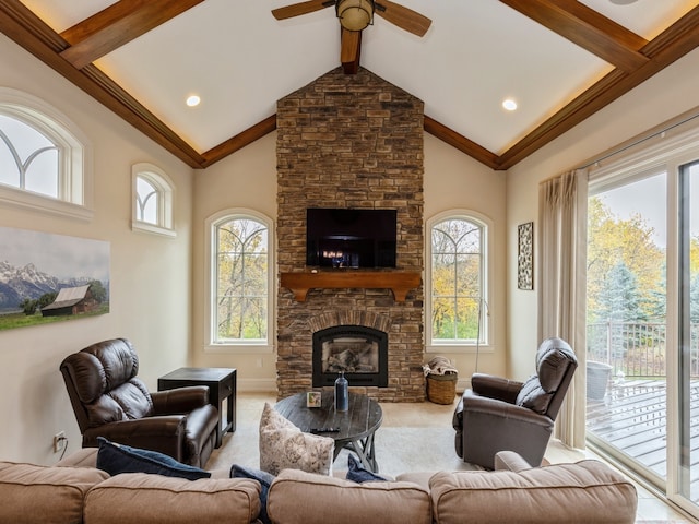 living room with high vaulted ceiling, beamed ceiling, a fireplace, and a healthy amount of sunlight