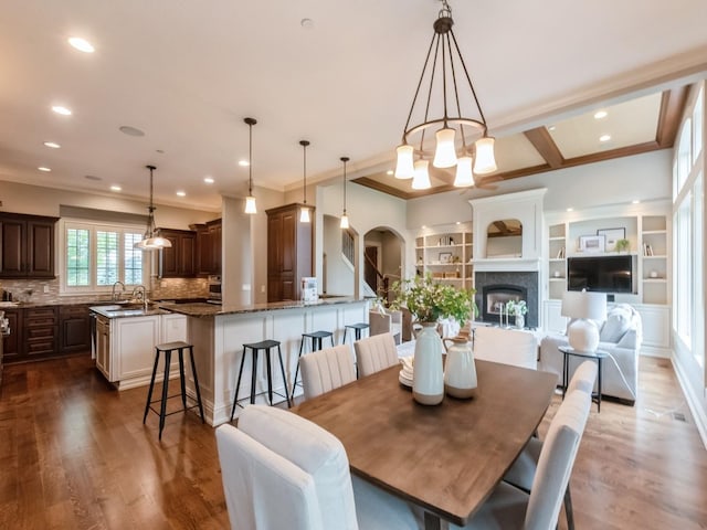 3123 162nd St, Urbandale, IA 50323 - dining space with ornamental molding, a chandelier, dark wood-style flooring, arched walkways, and recessed lighting