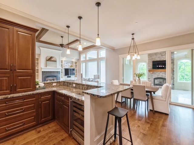3123 162nd St, Urbandale, IA 50323 - kitchen featuring a fireplace, open floor plan, wine cooler, crown molding, and beamed ceiling