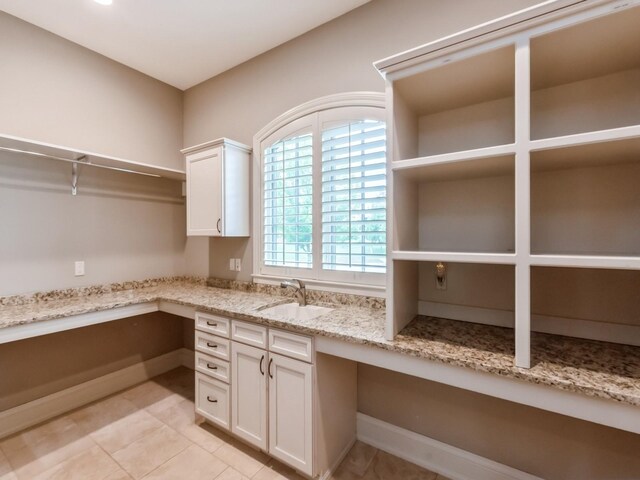 3123 162nd St, Urbandale, IA 50323 - kitchen featuring a sink, white cabinetry, open shelves, light tile patterned floors, and light stone counters