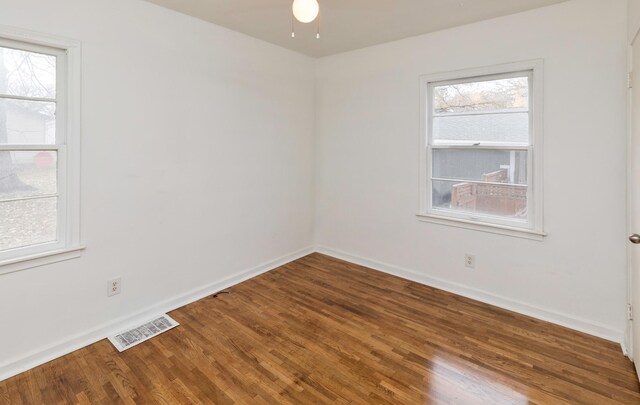 empty room featuring baseboards, visible vents, a ceiling fan, and wood finished floors