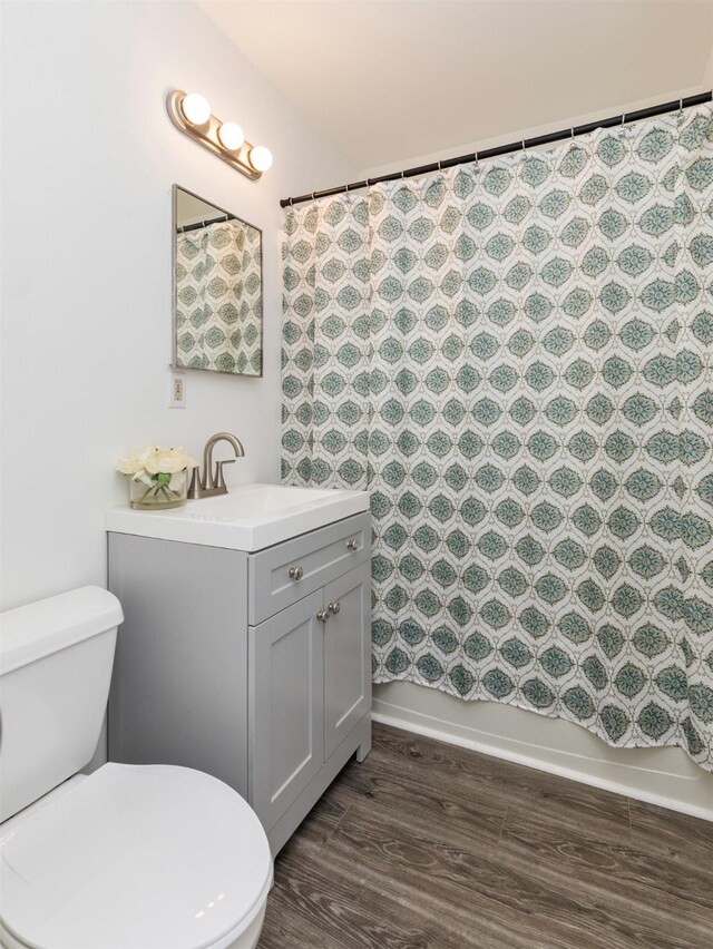 full bathroom with vanity, hardwood / wood-style flooring, toilet, and shower / bathtub combination with curtain