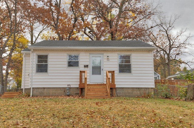 bungalow-style home featuring a front yard and fence