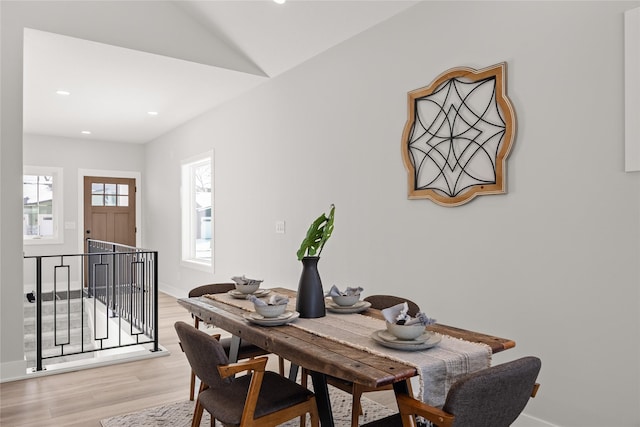 dining space featuring lofted ceiling and light hardwood / wood-style flooring