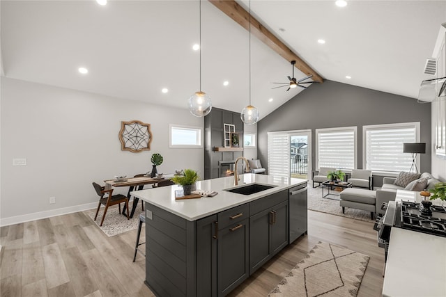 kitchen with ceiling fan, sink, dishwasher, light hardwood / wood-style floors, and an island with sink