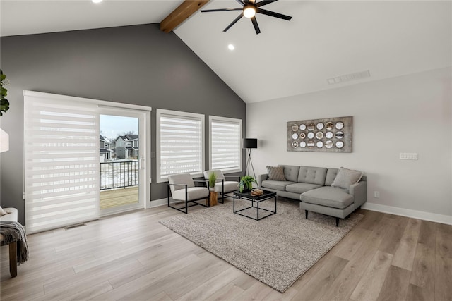 living room with ceiling fan, beamed ceiling, high vaulted ceiling, and light wood-type flooring