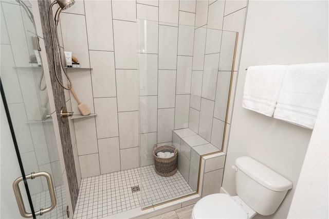 bathroom with toilet and a shower with shower door