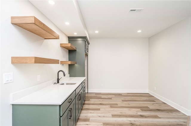 kitchen featuring gray cabinets, sink, and light hardwood / wood-style flooring