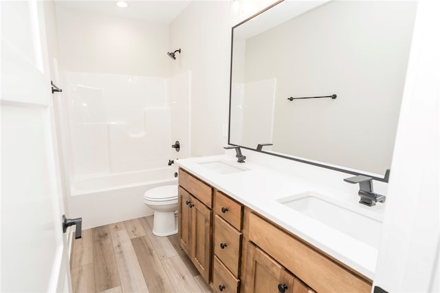 full bathroom with hardwood / wood-style flooring, vanity, toilet, and shower / tub combination