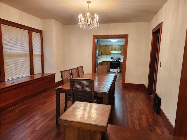 dining area featuring dark wood-type flooring and a notable chandelier