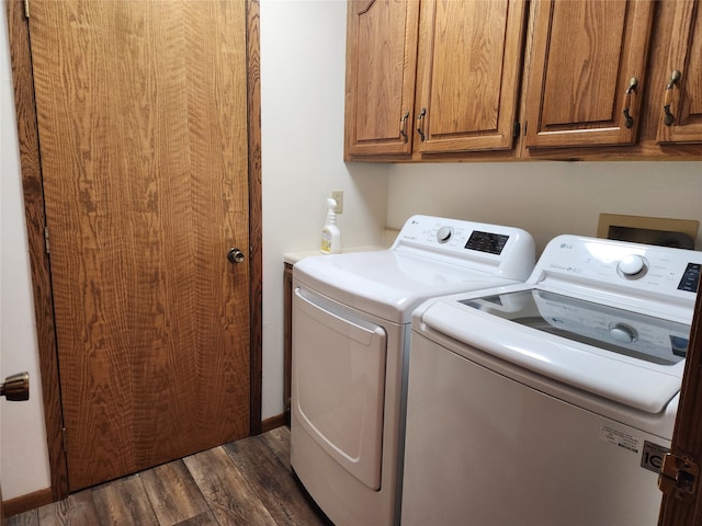 laundry area with dark wood-type flooring, cabinets, and independent washer and dryer