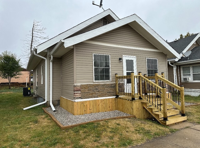 view of front of house with central air condition unit and a front yard