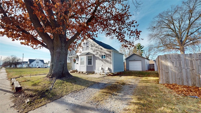 view of front facade with a garage, an outbuilding, and a front yard