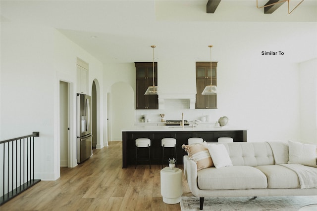 living room featuring light wood-type flooring, sink, and ceiling fan