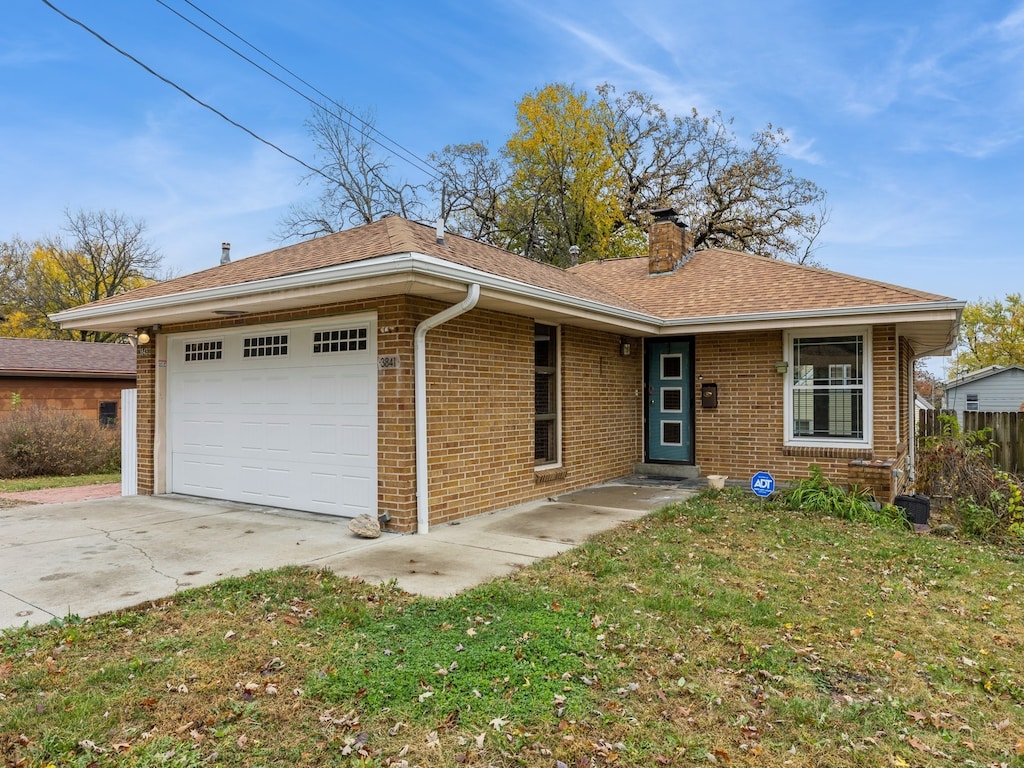 ranch-style house featuring a garage and a front yard