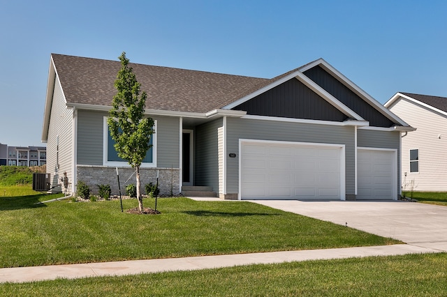 craftsman-style house with central AC unit, a garage, and a front lawn