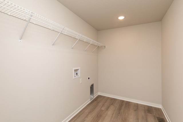 washroom with wood-type flooring, hookup for a washing machine, and electric dryer hookup