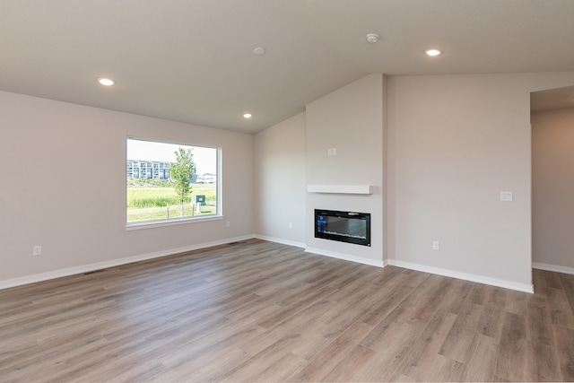 unfurnished living room with light hardwood / wood-style floors and lofted ceiling