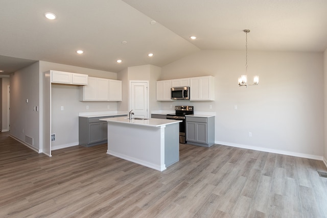 kitchen with gray cabinets, light wood-type flooring, an island with sink, and stainless steel appliances