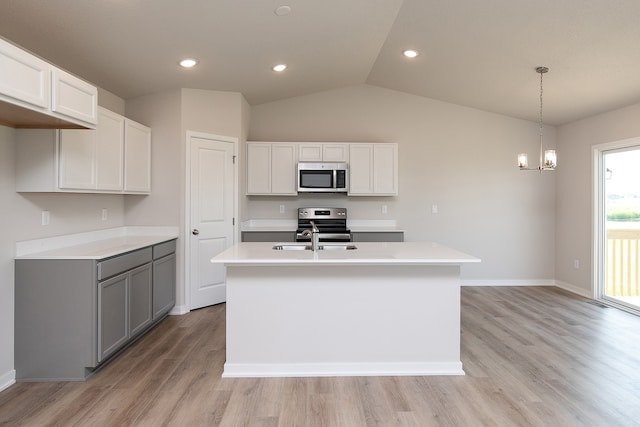 kitchen featuring light hardwood / wood-style floors, appliances with stainless steel finishes, a center island with sink, and white cabinets