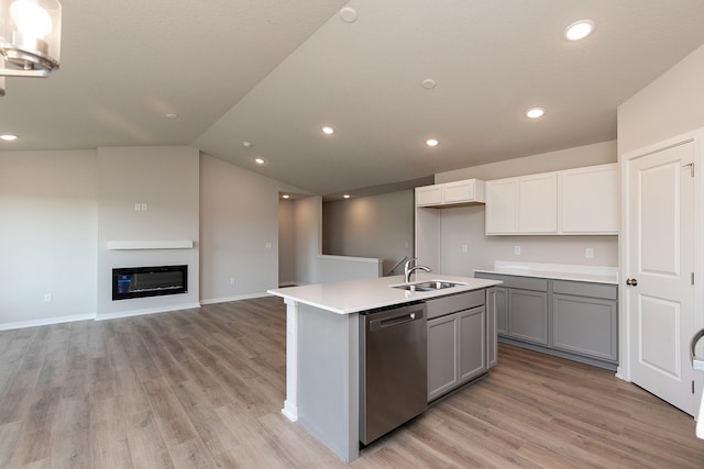 kitchen featuring lofted ceiling, white cabinets, sink, a kitchen island with sink, and stainless steel dishwasher