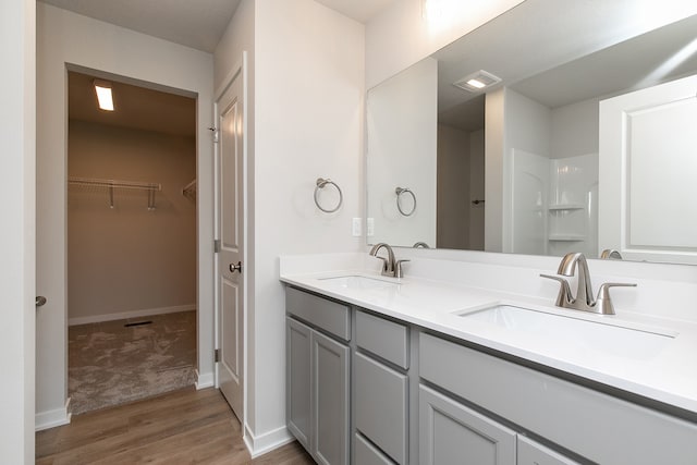 bathroom featuring a shower, vanity, and hardwood / wood-style flooring