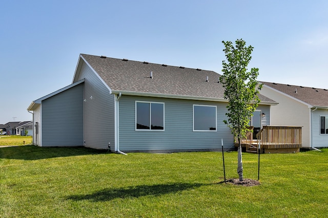 back of property featuring a lawn and a wooden deck