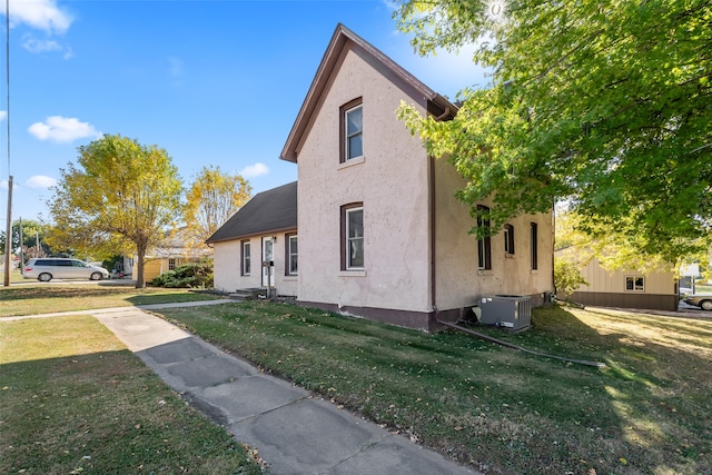 view of front of house featuring central AC and a front lawn