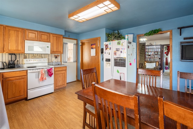 kitchen featuring white appliances, decorative backsplash, and light hardwood / wood-style floors