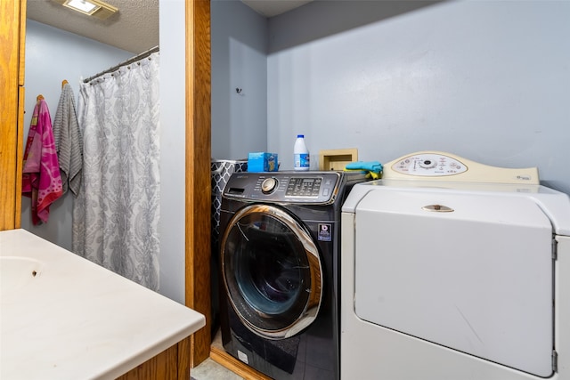 laundry area featuring a textured ceiling, tile patterned floors, and independent washer and dryer