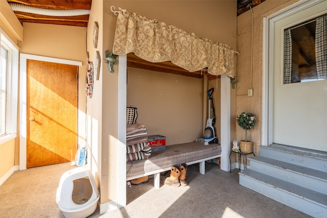 mudroom with carpet flooring and beam ceiling