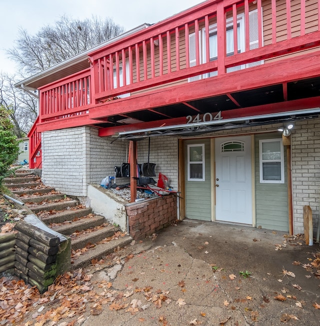 rear view of house featuring brick siding and a wooden deck