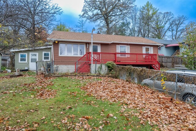 view of front facade featuring a front yard and a wooden deck