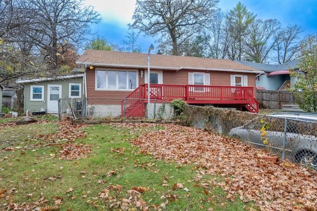 view of front of home featuring brick siding, a front lawn, fence, and a wooden deck