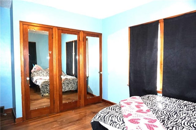 bedroom featuring baseboards and wood finished floors