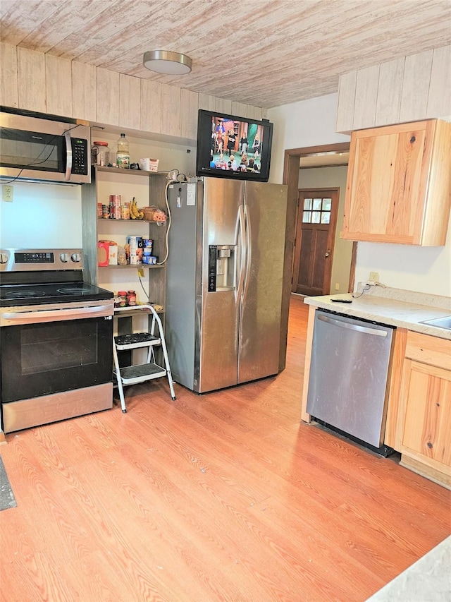 kitchen with light brown cabinetry, light wood finished floors, stainless steel appliances, and light countertops