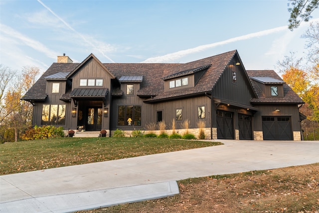 modern inspired farmhouse with a garage and a front lawn