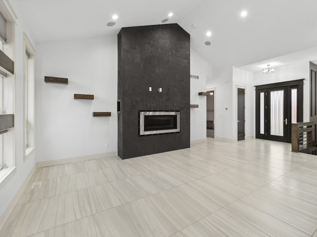 unfurnished living room featuring high vaulted ceiling