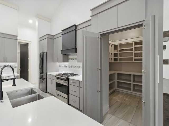 kitchen with decorative backsplash, stainless steel appliances, gray cabinetry, and sink